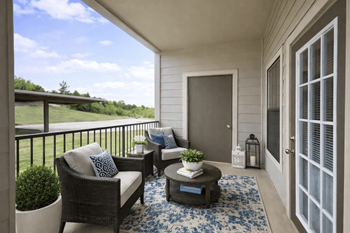 Covered patio with wicker seating and blue area rug